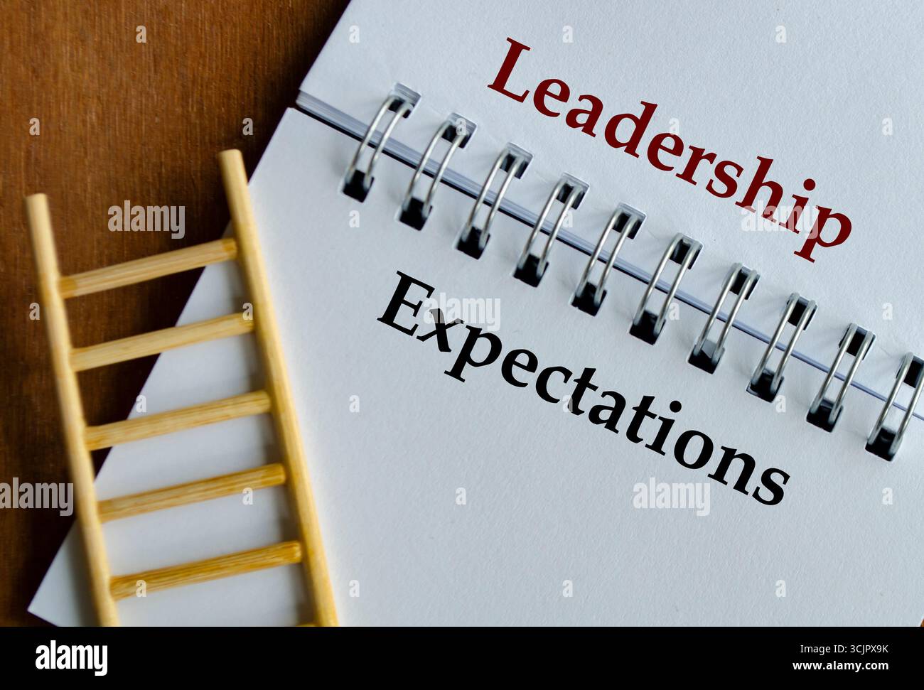 Blocco note con testo chiaro aspettative di leadership posizionate sulla scrivania con supporto visivo a scala Foto Stock