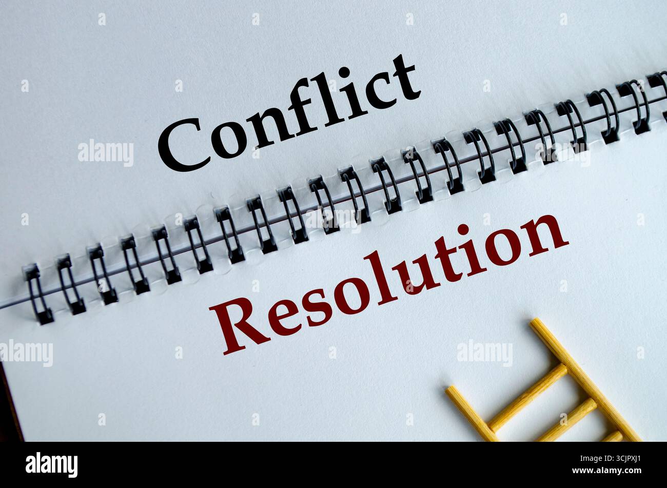 Risoluzione dei conflitti, blocco note con le parole in grassetto risoluzione dei conflitti scritte sul foglio bianco su una scrivania Foto Stock