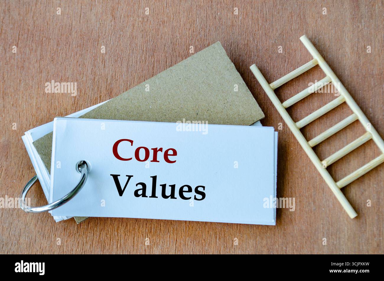 Blocco note accanto a una piccola scala con l'intestazione valori fondamentali in primo piano sul white paper Foto Stock