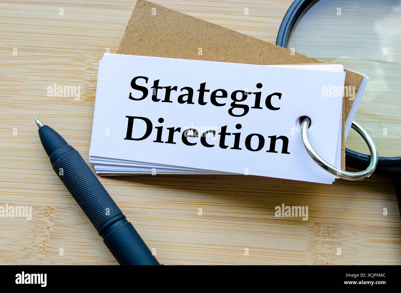 Direzione strategica, blocco note intitolato direzione strategica con scala in miniatura posizionata accanto su una superficie in legno Foto Stock