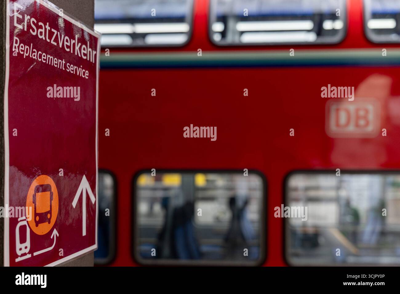 Ersatzverkehr am Bahnhof Hinweisschild zum Schienenersatzverkehr 08.09.25, Selters: Symbolfoto, Illustrationsbild, Symbolbild, Illustrationsfoto, Alltagsszene Ein Schild am Bahnsteig weist auf den Ersatzverkehr Hin. Der Hinweis in Deutsch und Englisch informiert Fahrgäste über den Schienenersatzverkehr servizio di sostituzione mit Bussen. Im Hintergrund ist unscharf ein roter Doppelstockzug der Deutschen Bahn zu sehen. Limburg Hessen Deutschland *** servizio di sostituzione alla stazione cartello per il servizio di sostituzione della ferrovia 08 09 25, foto simbolo Selter, foto illustrazione, immagine simbolo, foto illustrazione Foto Stock