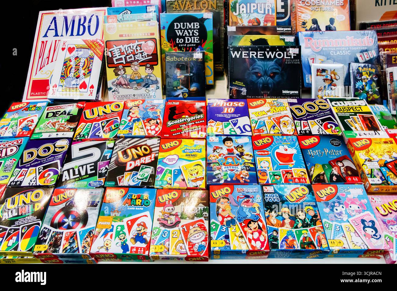Varietà di giochi di carte e da tavolo visualizzati su un tavolo, con giochi popolari come uno, Phase 10 e Werewolf in confezioni colorate malesia Foto Stock