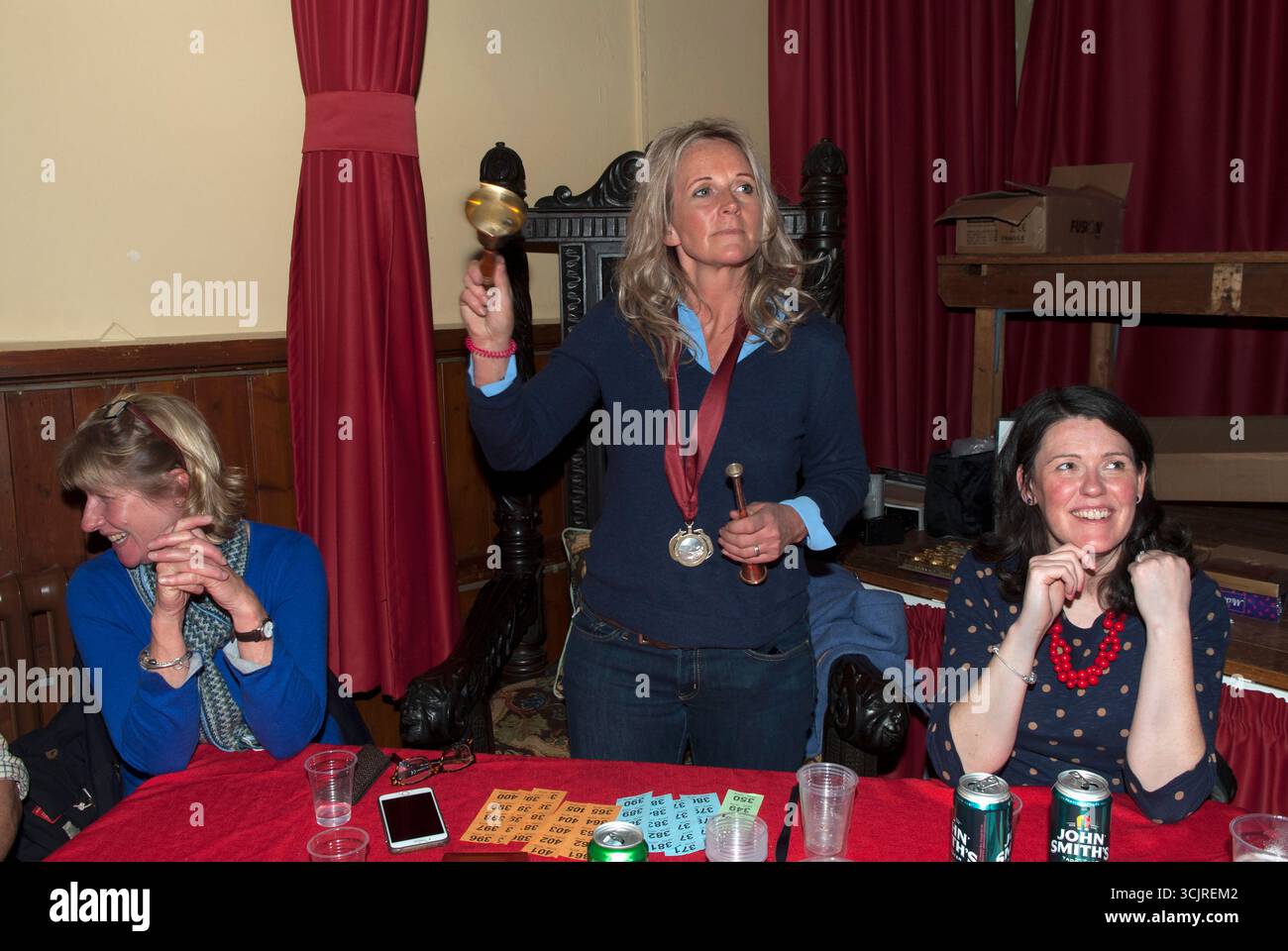 Troutbeck, Cumbria Lake District. Sindaco di Troutbeck, la signora Helen Westmoreland-Nicholson (2017-2018) indossa le sue insegne d'ufficio su un nastro cremisi; tenendo un corno di caccia siede al presidente dei sindaci e suona un campanello per l'ordine nella cerimonia annuale del Coniston Foxhounds Mayor, prima di annunciare chi sarà sindaco per l'anno successivo. (Visto qui con due membri del comitato di caccia) Troutbeck, Cumbria, Inghilterra 23 febbraio 2018 UK 2010s HOMER SYKES Foto Stock