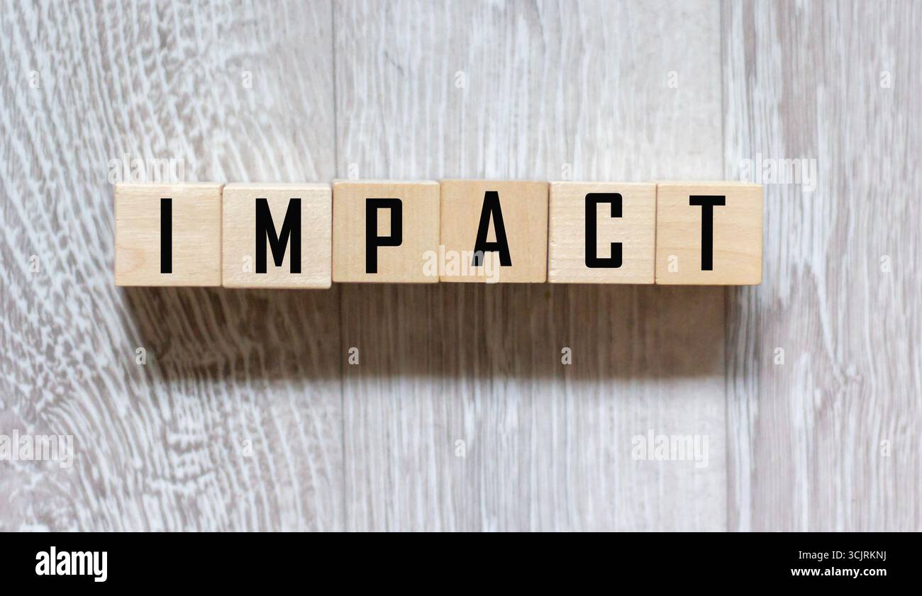 impact è un nome fatto di lettere di legno. Scrivania da ufficio Foto Stock