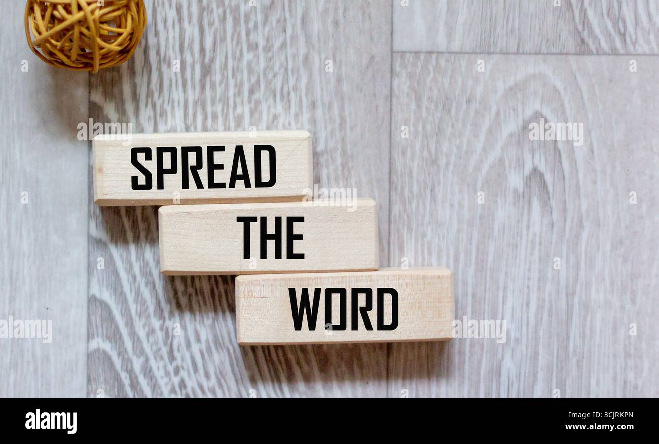 Blocco di legno con il testo CHE DIFFONDE LA PAROLA su uno sfondo grigio Foto Stock