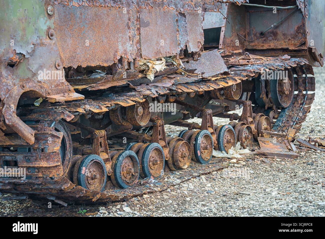 Binari del carro armato abbandonati stazione di Kinnvika Nordaustlandet Svalbard Norvegia // NORDEAUSTLANDET, Svalbard e Jan Mayen - i cingoli e le ruote di un veicolo militare abbandonato sono visibili in questa vista ravvicinata. L'esterno del veicolo presenta una corrosione significativa, con vernice staccabile e metallo esposto. Questa immagine è stata catturata a Nordaustlandet, un'isola remota nell'arcipelago delle Svalbard, situata nell'Oceano Artico. L'ampia ruggine e il deterioramento suggeriscono che il veicolo è stato esposto al difficile ambiente artico per un periodo considerevole. Foto Stock