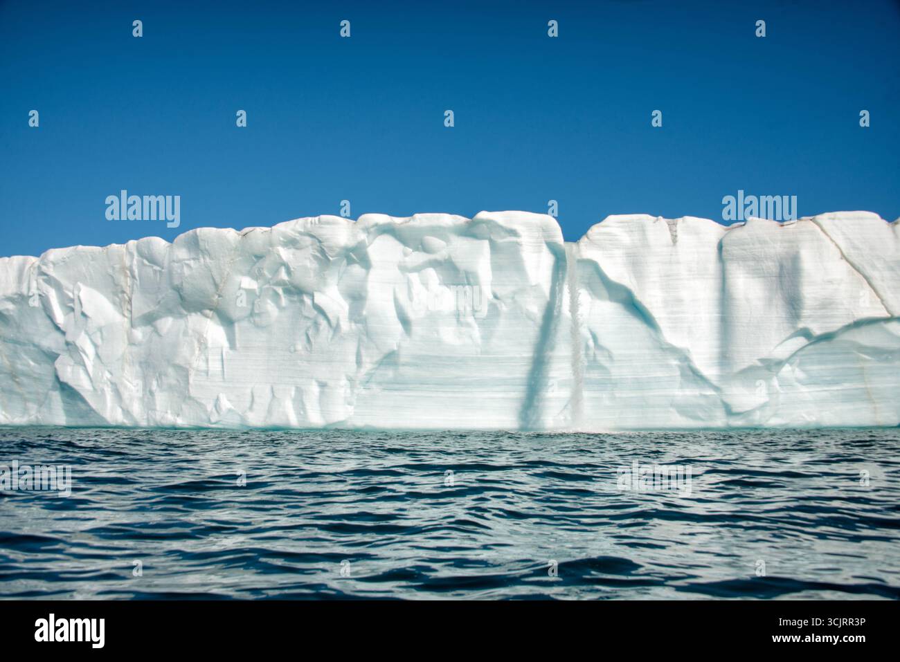 Cascata del ghiacciaio Bråsvellbreen Vibebukta Nordaustlandet Svalbard // NORDEAUSTLANDET, SVALBARD — Una cascata che si estende dal bordo del ghiacciaio Bråsvellbreen quando il ghiaccio si scioglie e scorre verso il mare. Bråsvellbreen è uno dei più grandi ghiacciai dell'isola di Nordaustlandet, parte dell'arcipelago delle Svalbard situato nell'Oceano Artico. Il fronte di ghiaccio del ghiacciaio è una caratteristica dinamica, costantemente modellata da processi di fusione e distacco. Foto Stock