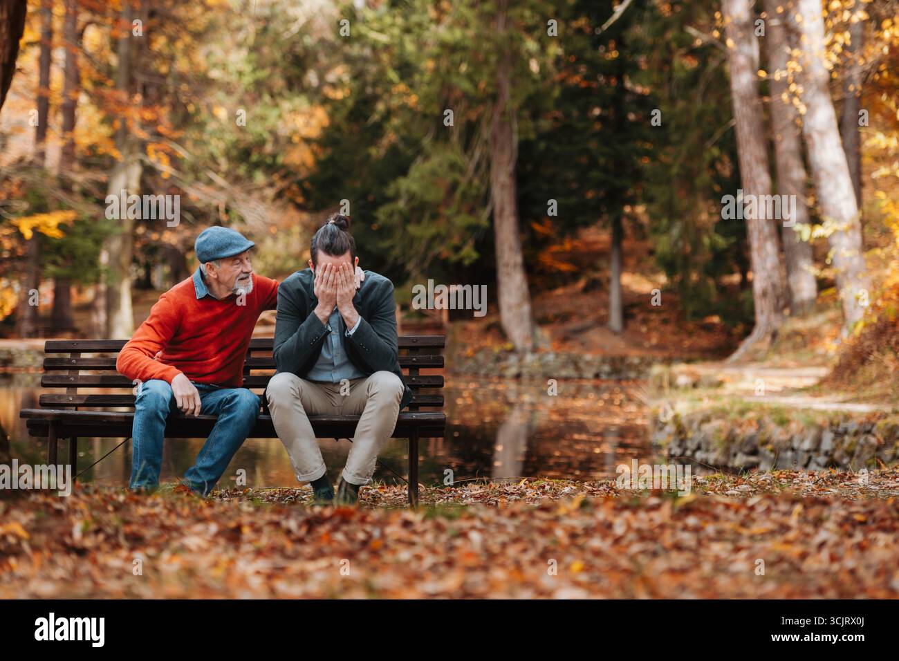 Padre più anziano che conforta il figlio sconvolto. Foto Stock
