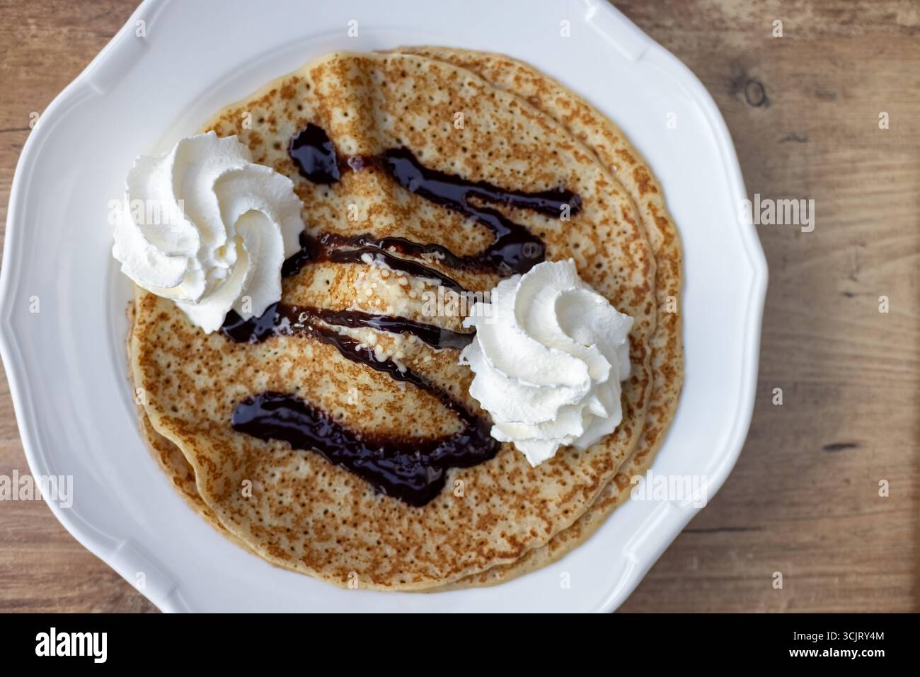 Deliziose frittelle dorate con ricco cioccolato, panna montata e crema gelato. Vista dall'alto. Foto Stock