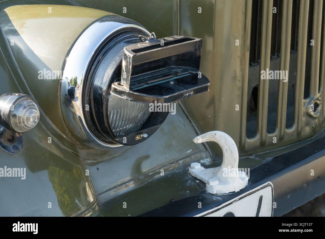 Primo piano della copertura oscurante dei fari di un veicolo militare d'epoca, che mostra il suo design funzionale e la sua struttura robusta. Foto Stock