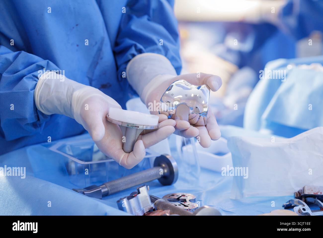 Il chirurgo ortopedico mostra le parti dell'impianto di sostituzione del ginocchio su un telo sterile durante la preparazione dell'artroplastica, ideale per l'educazione medica e il marketing Foto Stock