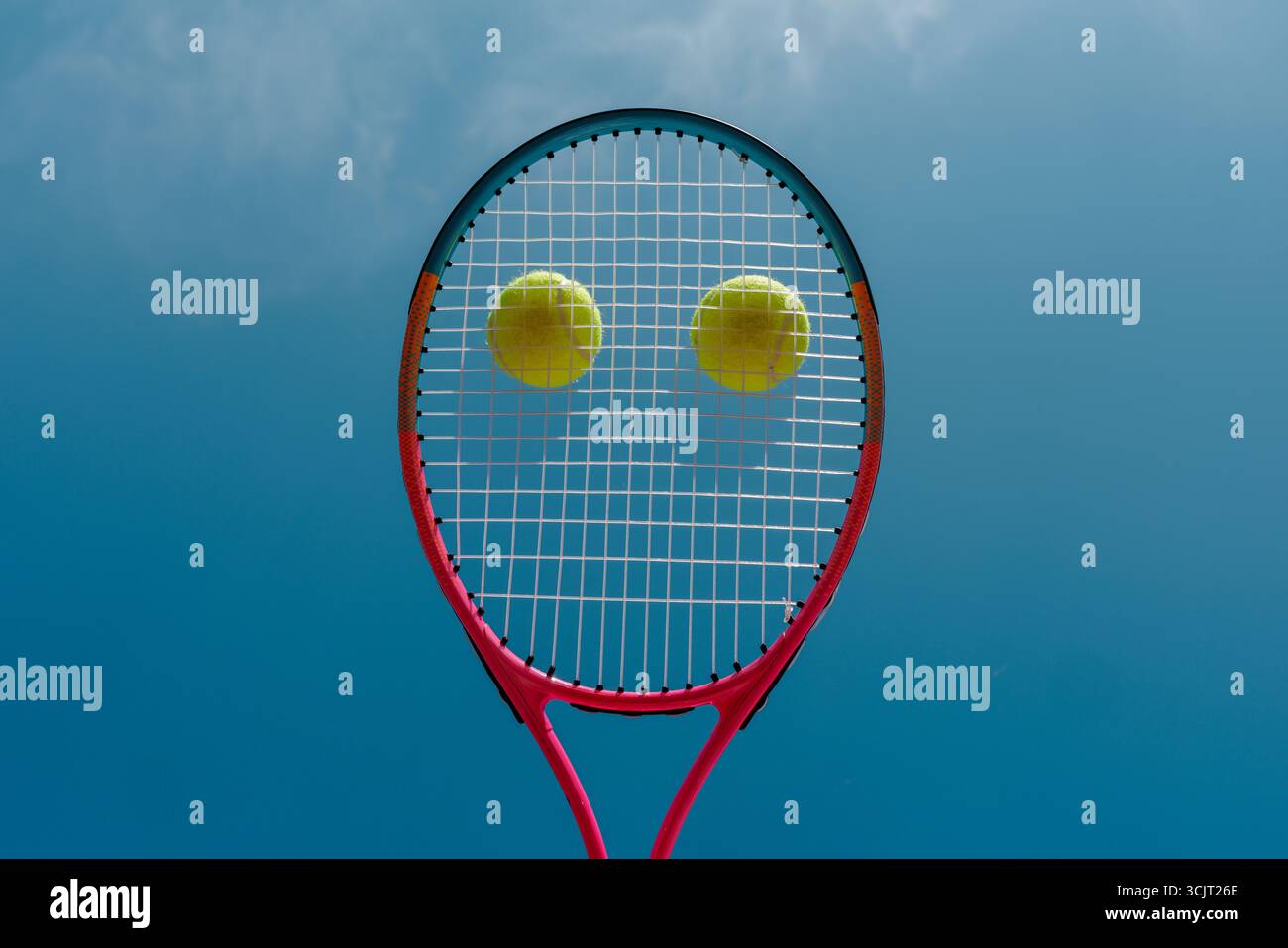 Primo piano concettuale della racchetta da tennis con due palline che rendono il viso contro il cielo blu un design sportivo minimalista creativo con spazio per copiare Foto Stock