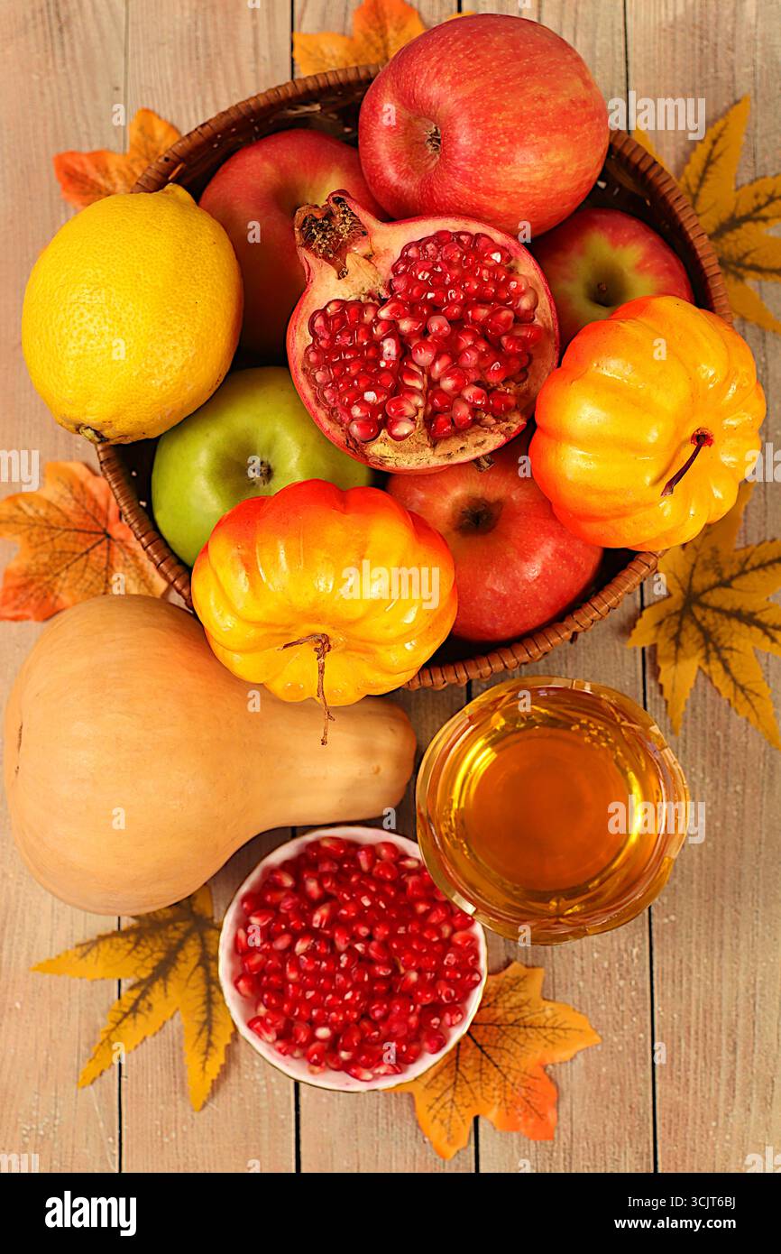 Vendemmia, striscione del Ringraziamento, sfondo autunnale con mele, melograni, zucche, miele, uva, fiori sotto girasoli e foglie su woo Foto Stock