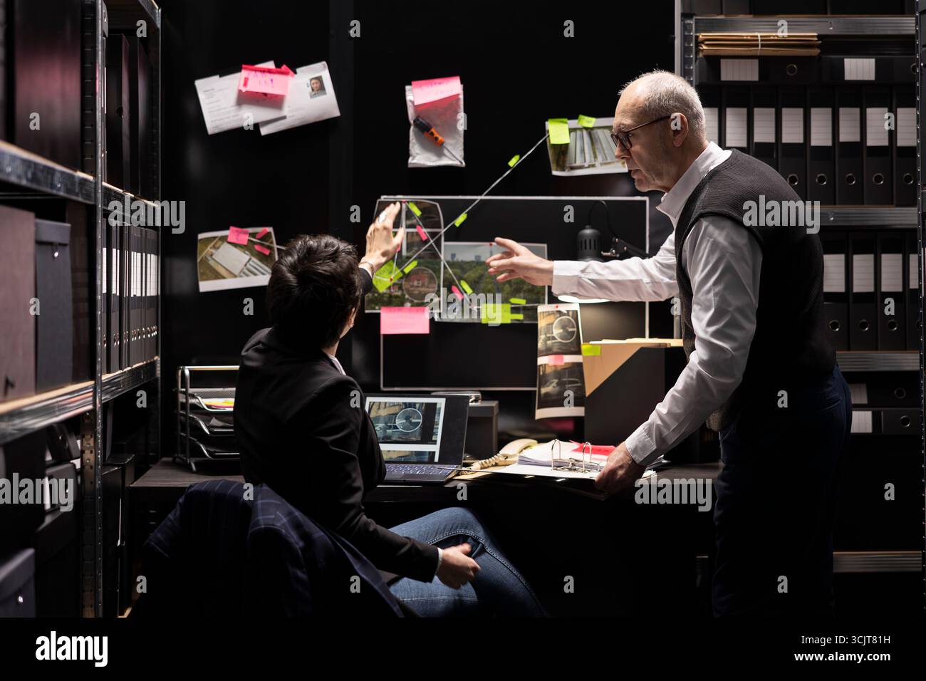 Squadra di investigatori privati che conduce controlli sui sospetti, lavoro investigativo su un'operazione clandestina. Colleghi che raccolgono informazioni e interpretano le prove. Foto Stock