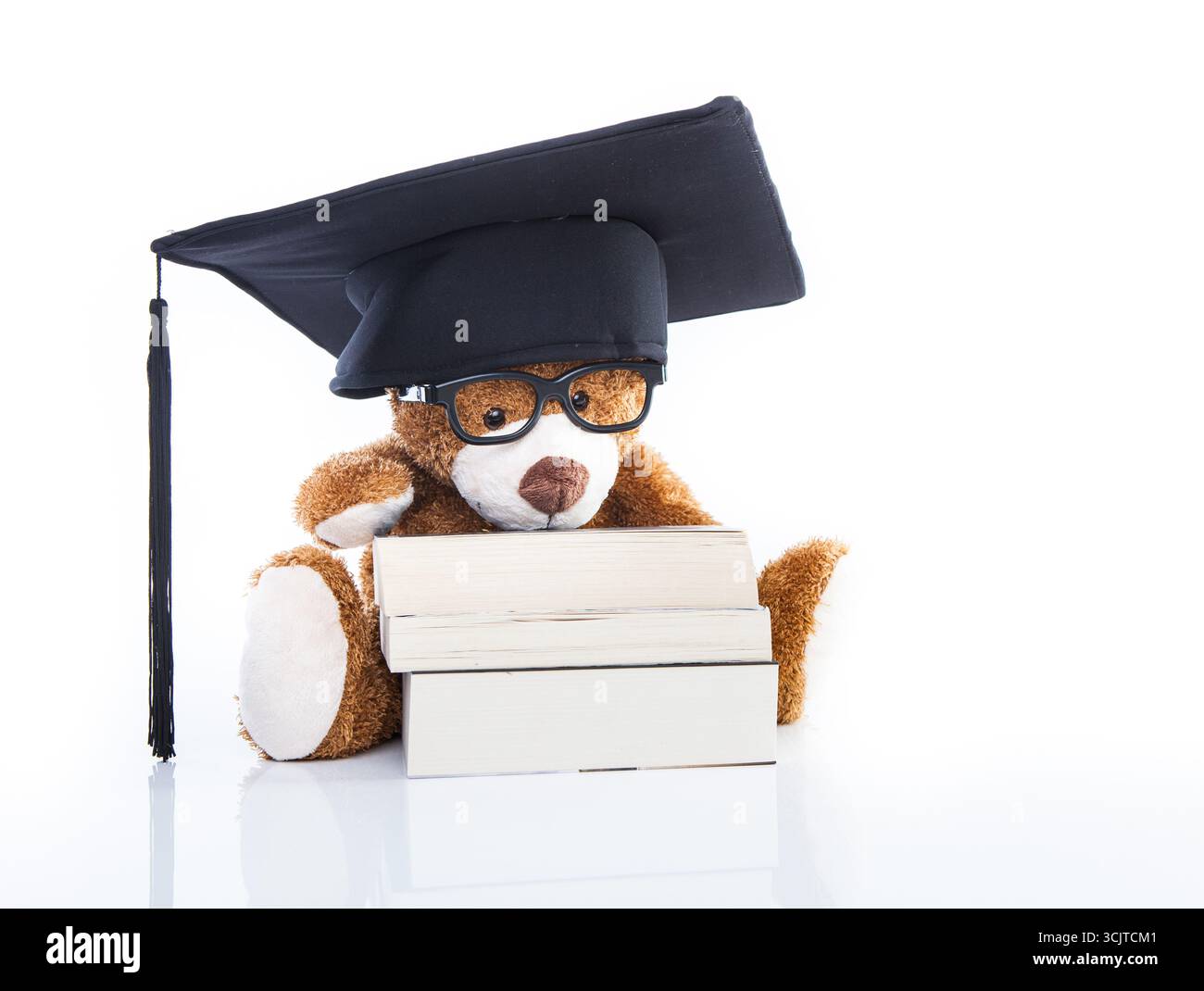 Orsacchiotto con occhiali, cappello da medico e pila di libri Foto Stock