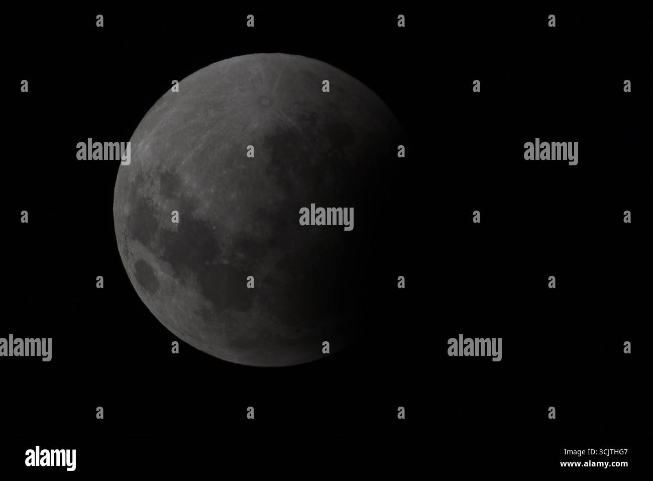 Melbourne, Victoria, Australia. 8 settembre 2025. La luna piena ritorna alla fase di eclissi parziale dopo la sua eclissi totale durante il fenomeno dell'eclissi lunare totale della Luna di sangue come visto a Melbourne City, Victoria. La luna piena dipinta di rosso è vista come la seconda eclissi lunare totale dell'anno in cui la luna si trova in profondità nella parte più oscura della Terra dell'ombra del nostro pianeta, creando una drammatica ''luna di sangue'' Un'eclissi lunare totale della Luna di sangue è stata visibile il 7/8 settembre 2025. Osservatori con sede in Pakistan, India, Cina, Russia, Australia e nuova Zelanda, Africa orientale e nelle regioni circostanti centr Foto Stock