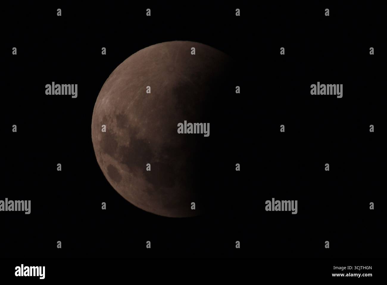 Melbourne, Victoria, Australia. 8 settembre 2025. La luna piena ritorna alla fase di eclissi parziale dopo la sua eclissi totale durante il fenomeno dell'eclissi lunare totale della Luna di sangue come visto a Melbourne City, Victoria. La luna piena dipinta di rosso è vista come la seconda eclissi lunare totale dell'anno in cui la luna si trova in profondità nella parte più oscura della Terra dell'ombra del nostro pianeta, creando una drammatica ''luna di sangue'' Un'eclissi lunare totale della Luna di sangue è stata visibile il 7/8 settembre 2025. Osservatori con sede in Pakistan, India, Cina, Russia, Australia e nuova Zelanda, Africa orientale e nelle regioni circostanti centr Foto Stock