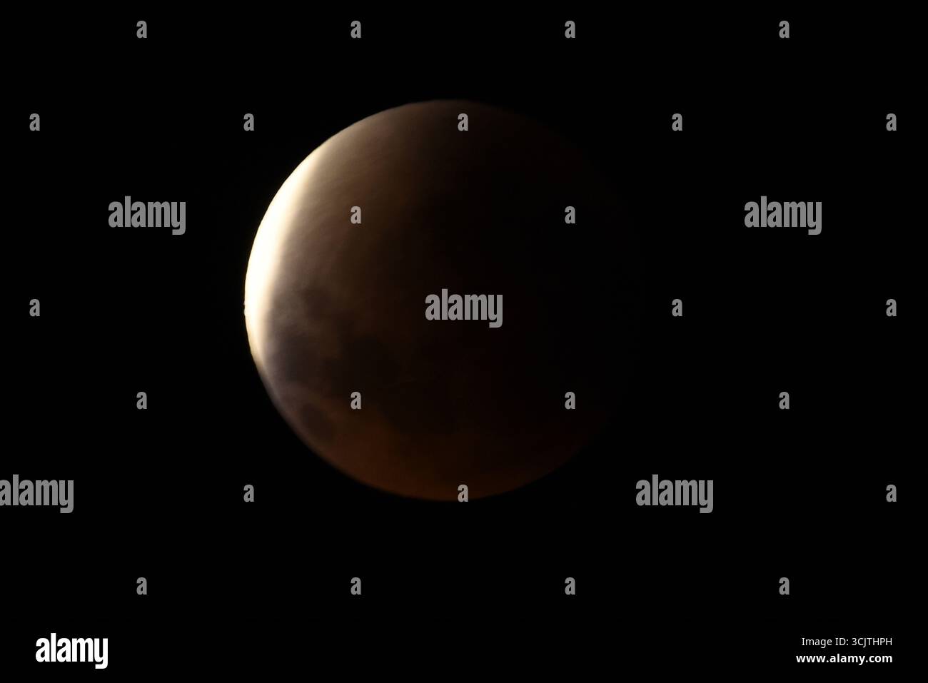 Melbourne, Victoria, Australia. 8 settembre 2025. La luna piena ritorna alla fase di eclissi parziale dopo la sua eclissi totale durante il fenomeno dell'eclissi lunare totale della Luna di sangue come visto a Melbourne City, Victoria. La luna piena dipinta di rosso è vista come la seconda eclissi lunare totale dell'anno in cui la luna si trova in profondità nella parte più oscura della Terra dell'ombra del nostro pianeta, creando una drammatica ''luna di sangue'' Un'eclissi lunare totale della Luna di sangue è stata visibile il 7/8 settembre 2025. Osservatori con sede in Pakistan, India, Cina, Russia, Australia e nuova Zelanda, Africa orientale e nelle regioni circostanti centr Foto Stock