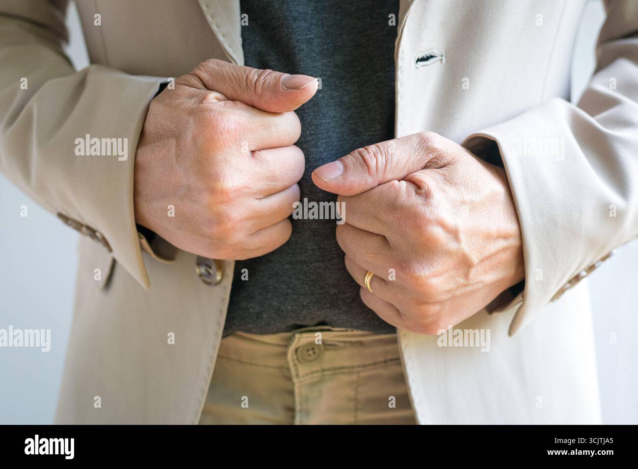 Uomo d'affari con le mani che raddrizzano il blazer o la giacca. Vista frontale, primo piano. Foto Stock