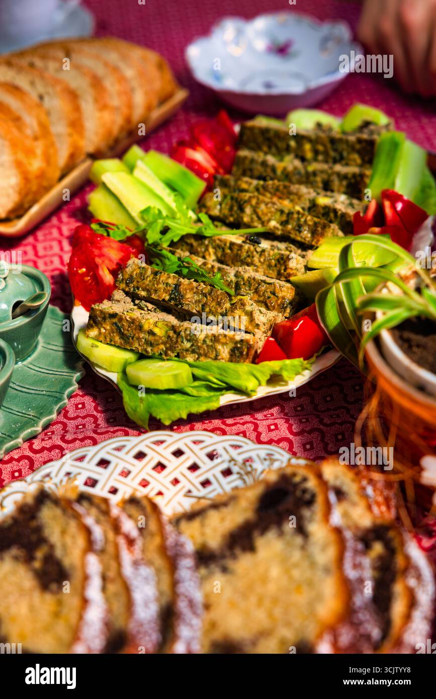 Rustico tavolo pasquale rumeno con salsa di agnello alle erbe e uovo insieme al dolce pane cozonac con uvetta e cacao, simboleggia la celebrazione e. Foto Stock