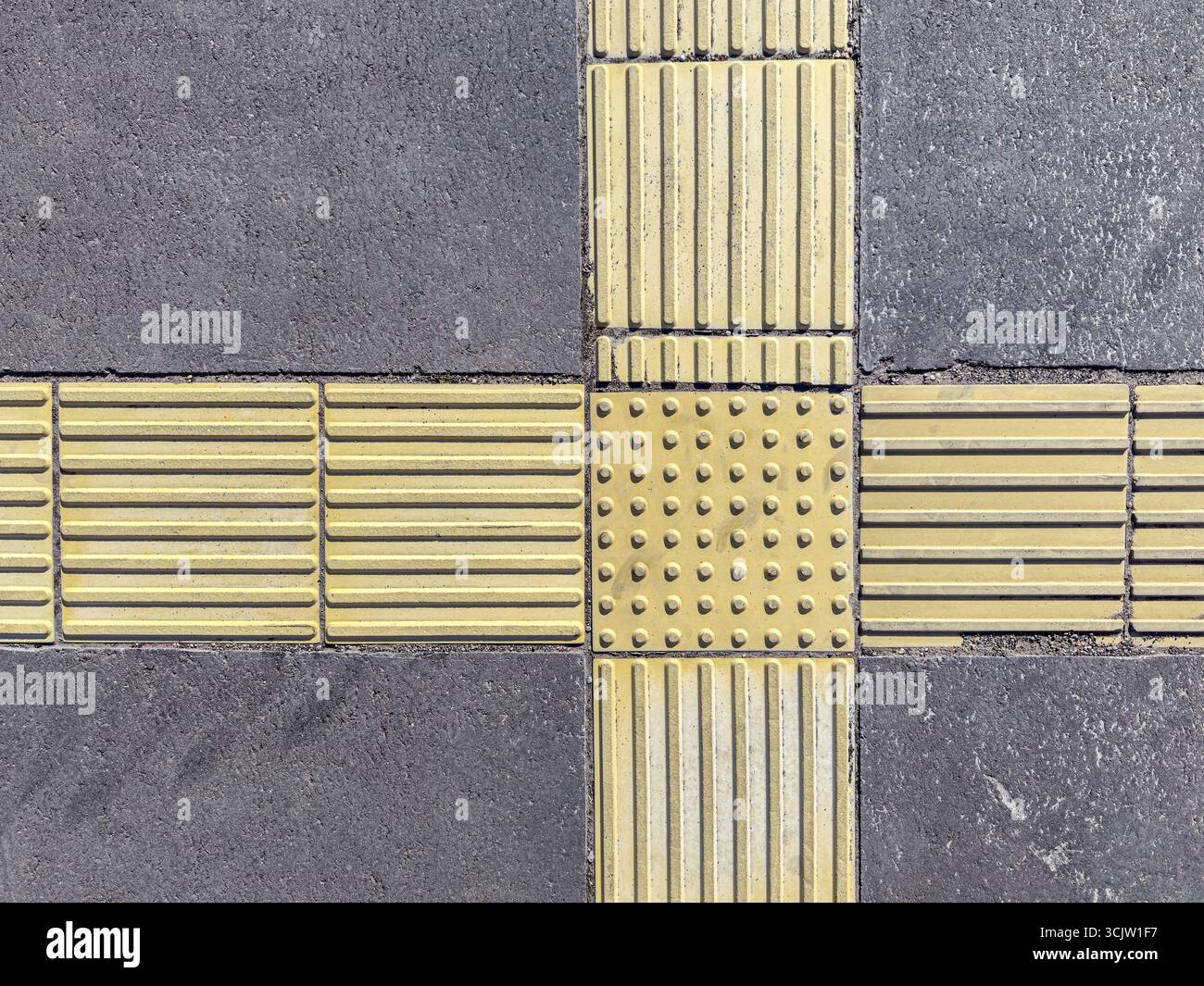 strisce gialle e bottoni sulla pavimentazione. indicatori tattili per non vedenti. Foto Stock