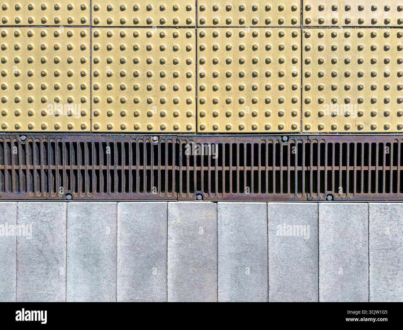 moderna pavimentazione della città. indicatori tattili antiscivolo, reticolo di drenaggio dei metalli, pavimentazione in calcestruzzo. vista dall'alto. Foto Stock