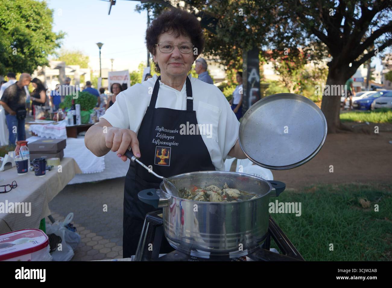 Parte di una serie, una cuoca donna presenta il suo pollo tradizionale con finocchio alla macchina fotografica all'11 ° Festival della cucina cretese Foto Stock