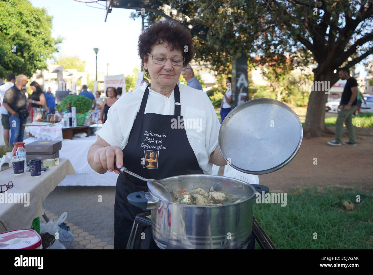 Parte di una serie, una cuoca donna presenta il suo pollo tradizionale con finocchio alla macchina fotografica all'11 ° Festival della cucina cretese Foto Stock