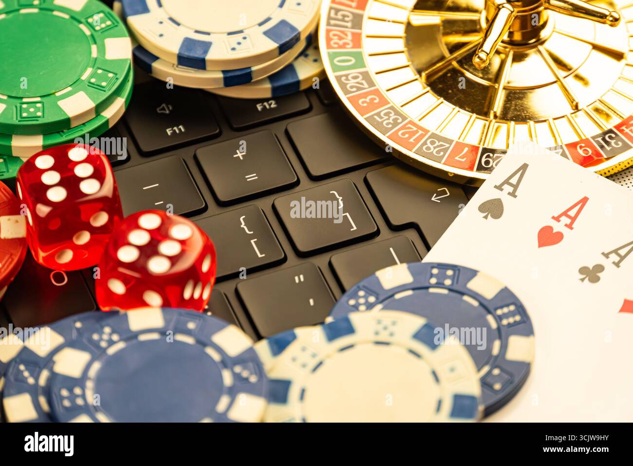 L'immagine mostra una raccolta di oggetti di gioco d'azzardo su un computer portatile, suggerendo giochi online o app per casinò, tra cui carte da gioco, chip per casinò, roulette Foto Stock