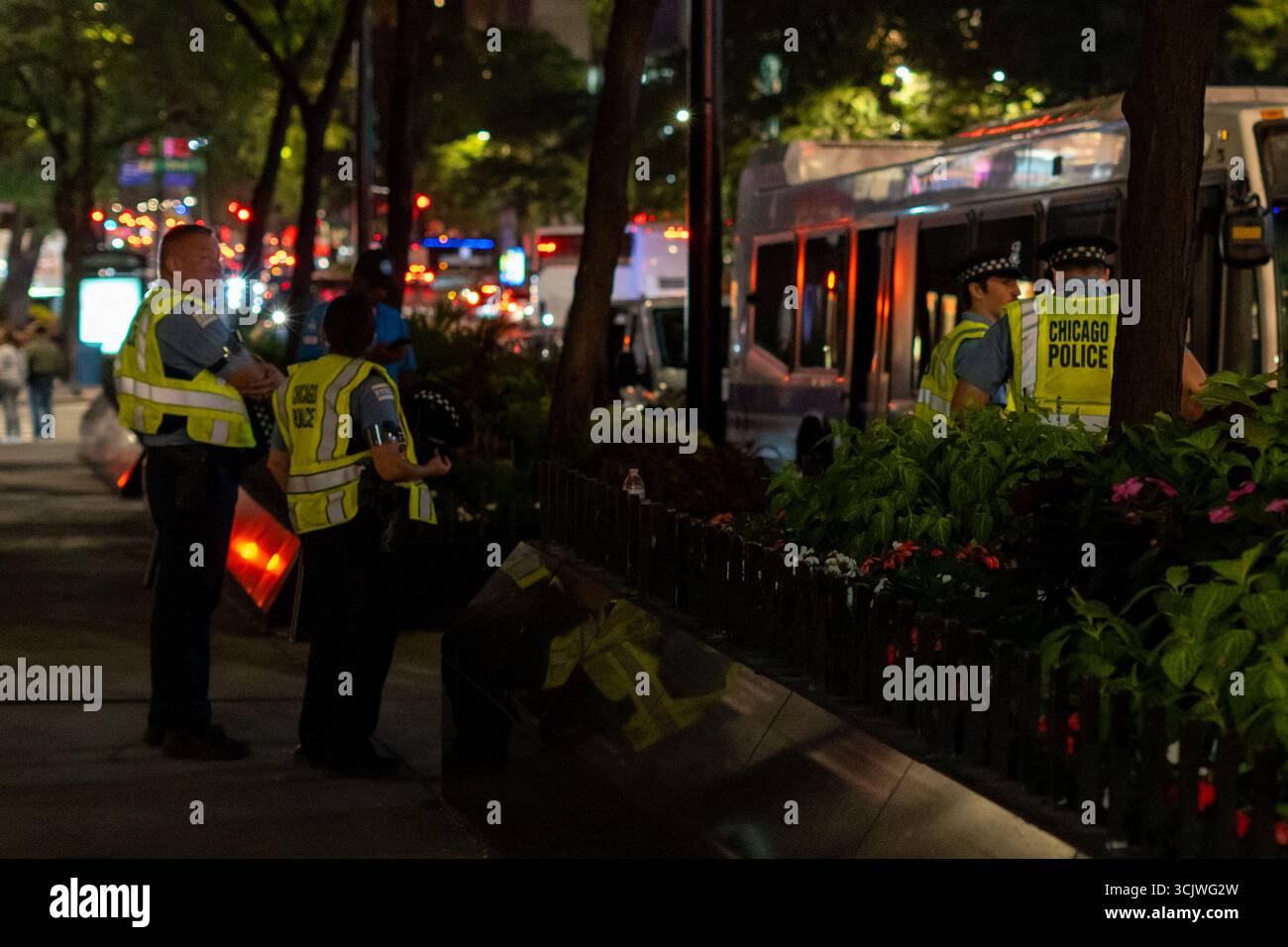 Gli agenti di polizia pattugliano una tranquilla strada urbana di notte, simboleggiando l'autorità, la sicurezza pubblica e l'impegno per la protezione della comunità dopo il tramonto. Foto Stock