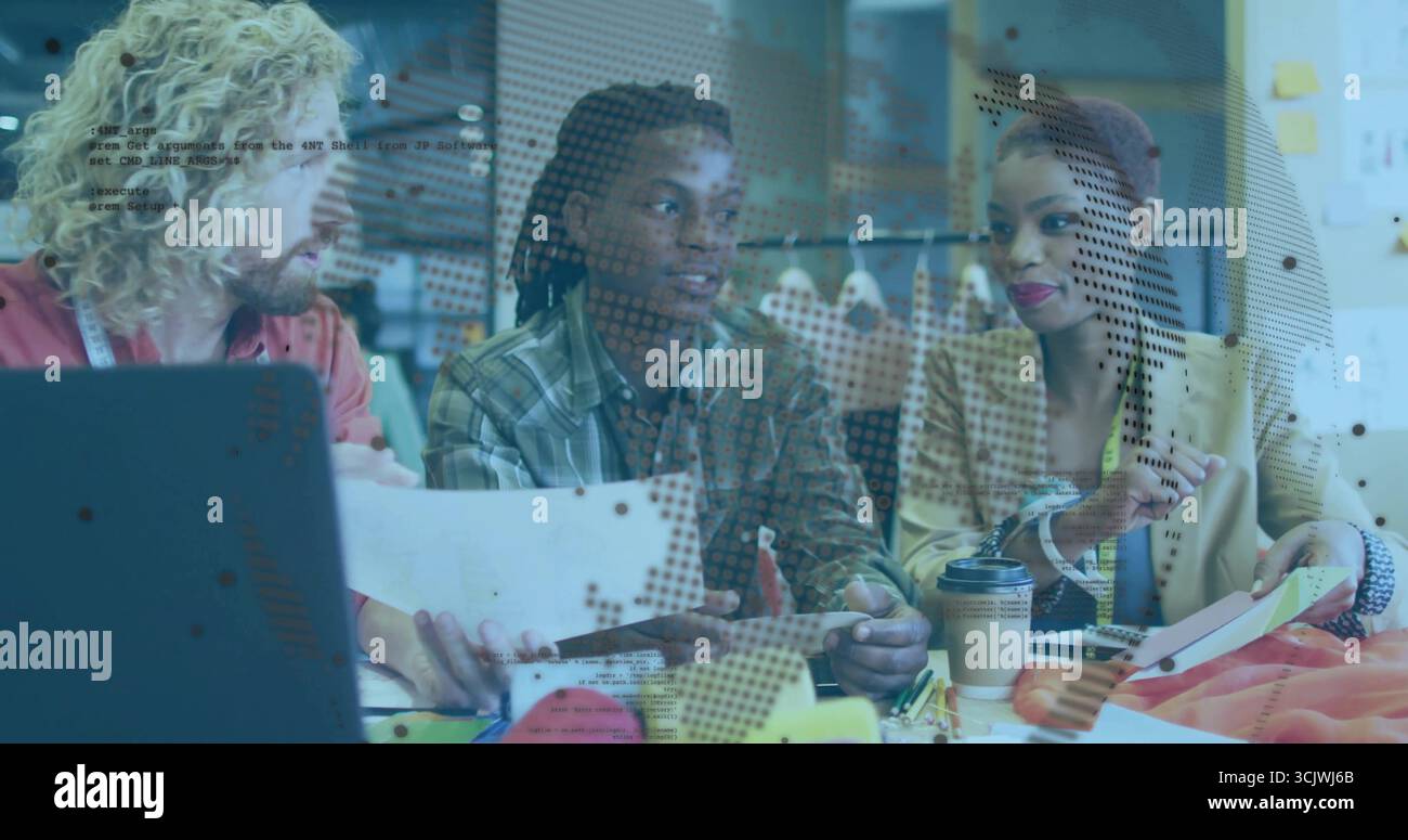 Collaborazione con tre colleghi che esaminano schizzi e campioni di tessuto in studio di progettazione, con un computer portatile Foto Stock