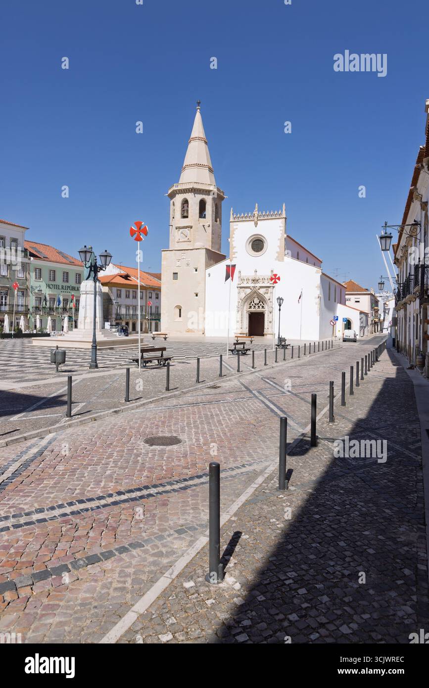 L'imponente facciata della Chiesa di San Giovanni Battista, caratterizzata da un campanile e da intricati dettagli gotici, si erge in una grande piazza pavimentata. A. Foto Stock