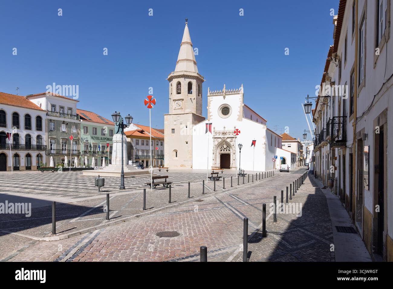 L'imponente facciata della Chiesa di San Giovanni Battista, caratterizzata da un campanile e da intricati dettagli gotici, si erge in una grande piazza pavimentata. A. Foto Stock