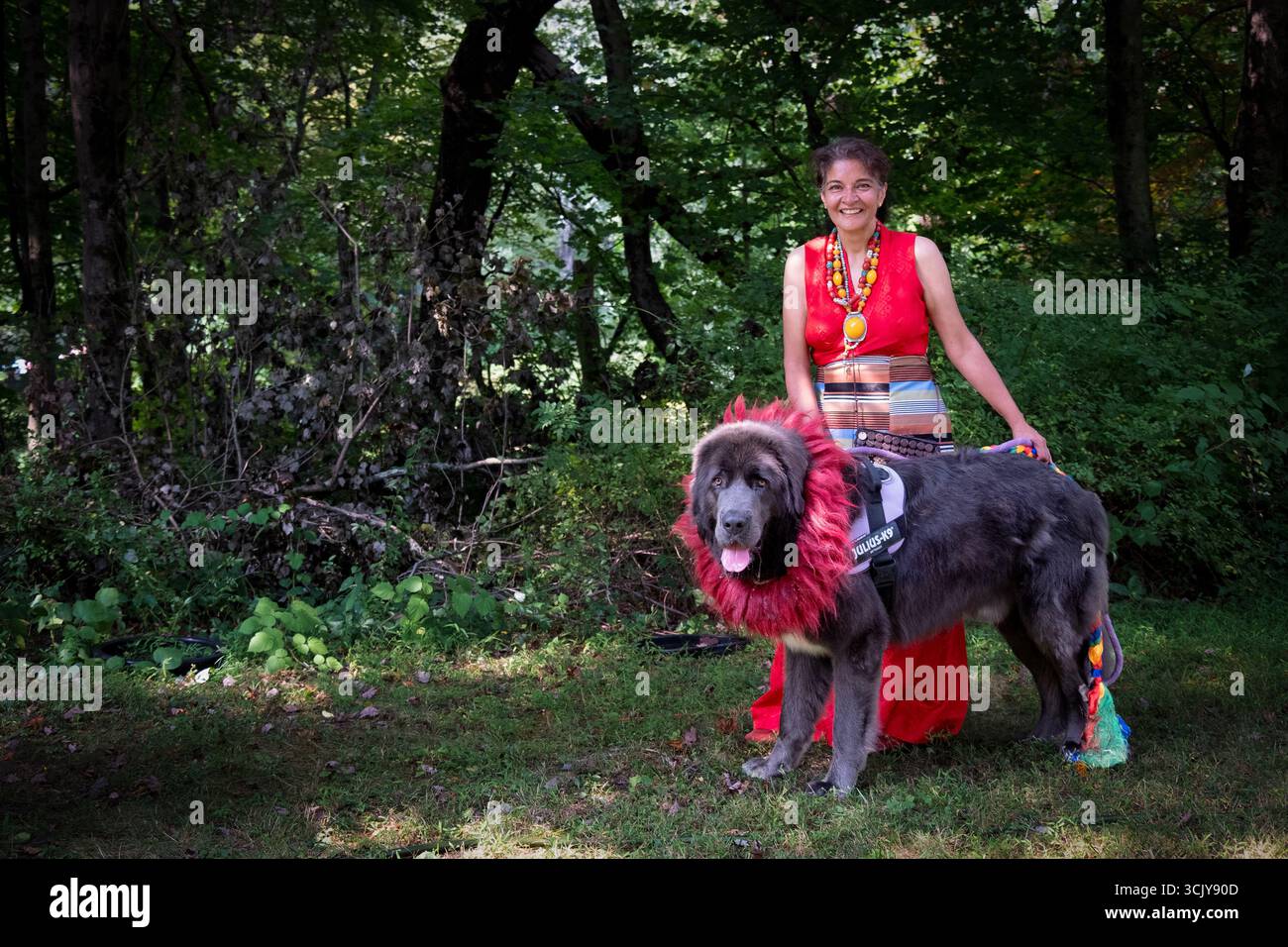 Ritratto in posa di una donna tibetana con il suo mastino tibetano in un monastero tibetano. Foto Stock