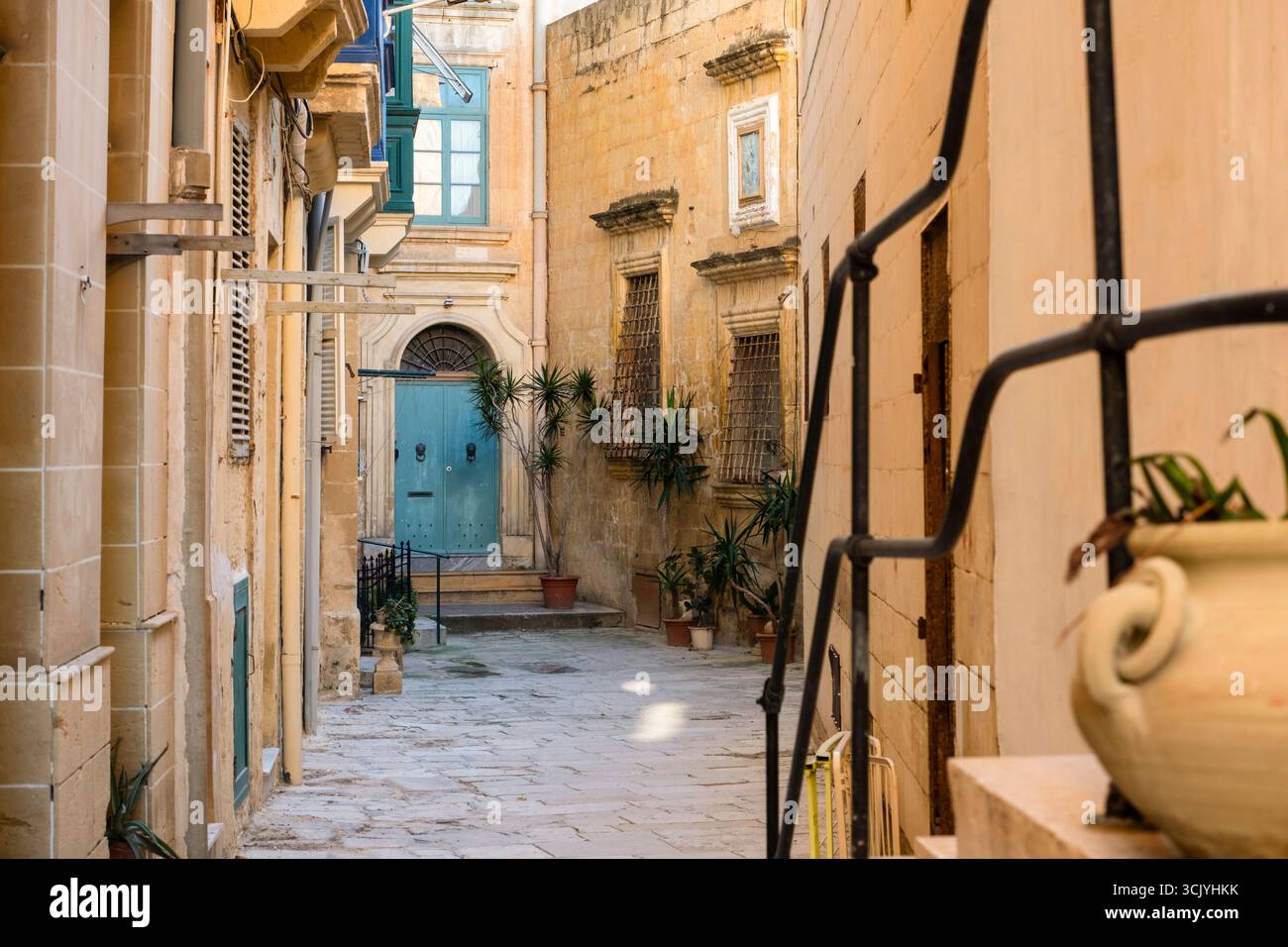 Strada con meravigliose e meravigliose case storiche con balconi in legno blu a la Valletta, capitale di Malta Foto Stock
