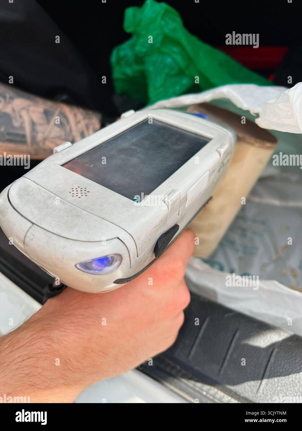 Gorodok, Ucraina - 15 agosto 2025: Primo piano dello scanner del convertitore catalitico dell'analizzatore XRF in uso, tenuto in mano. Foto Stock