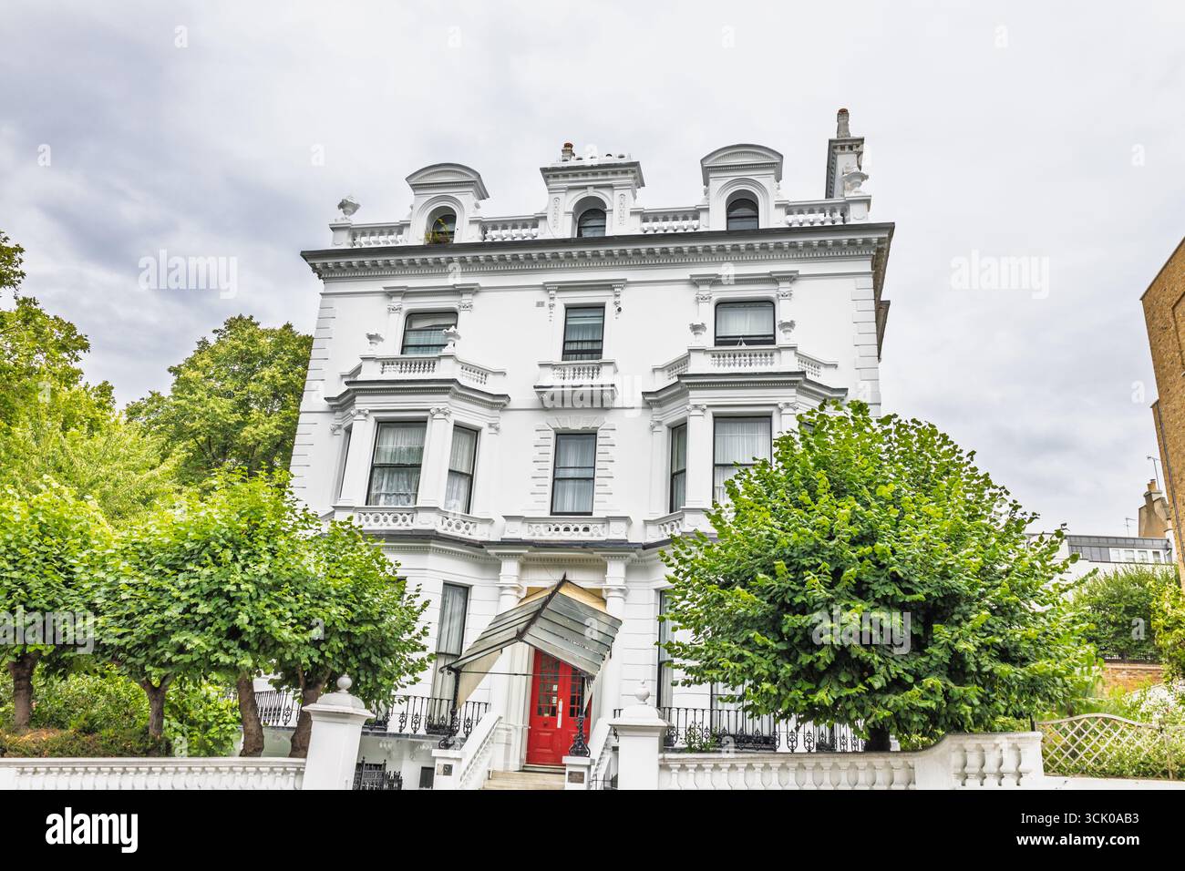 Elegante residenza vittoriana bianca con porta rossa a Londra, storica architettura stucco Foto Stock
