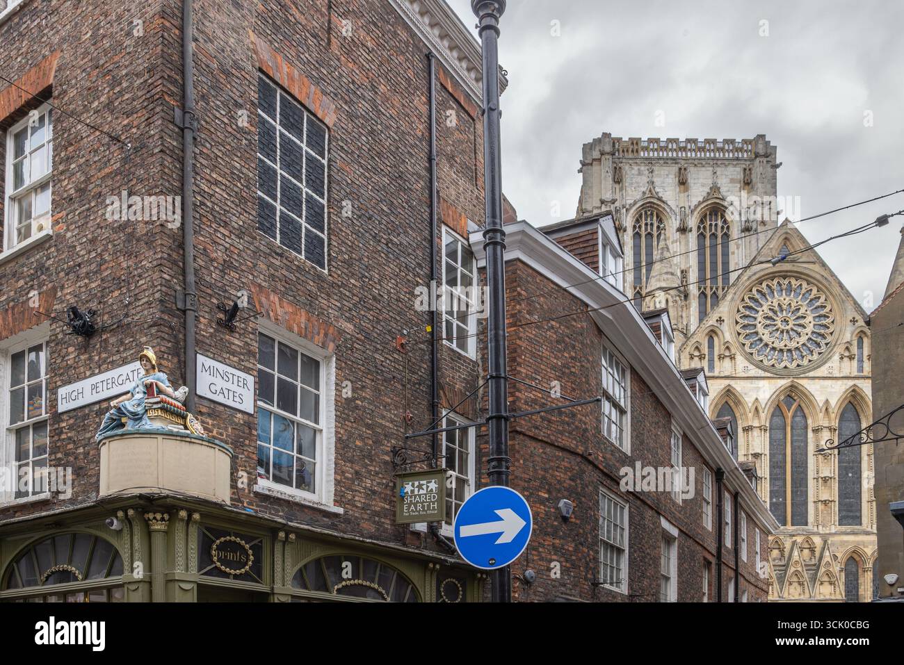 Vista della cattedrale di York dall'High Petergate e dalla Minster Gates di York, in Inghilterra, con architettura storica e scultura della dea Minerva in primo piano Foto Stock