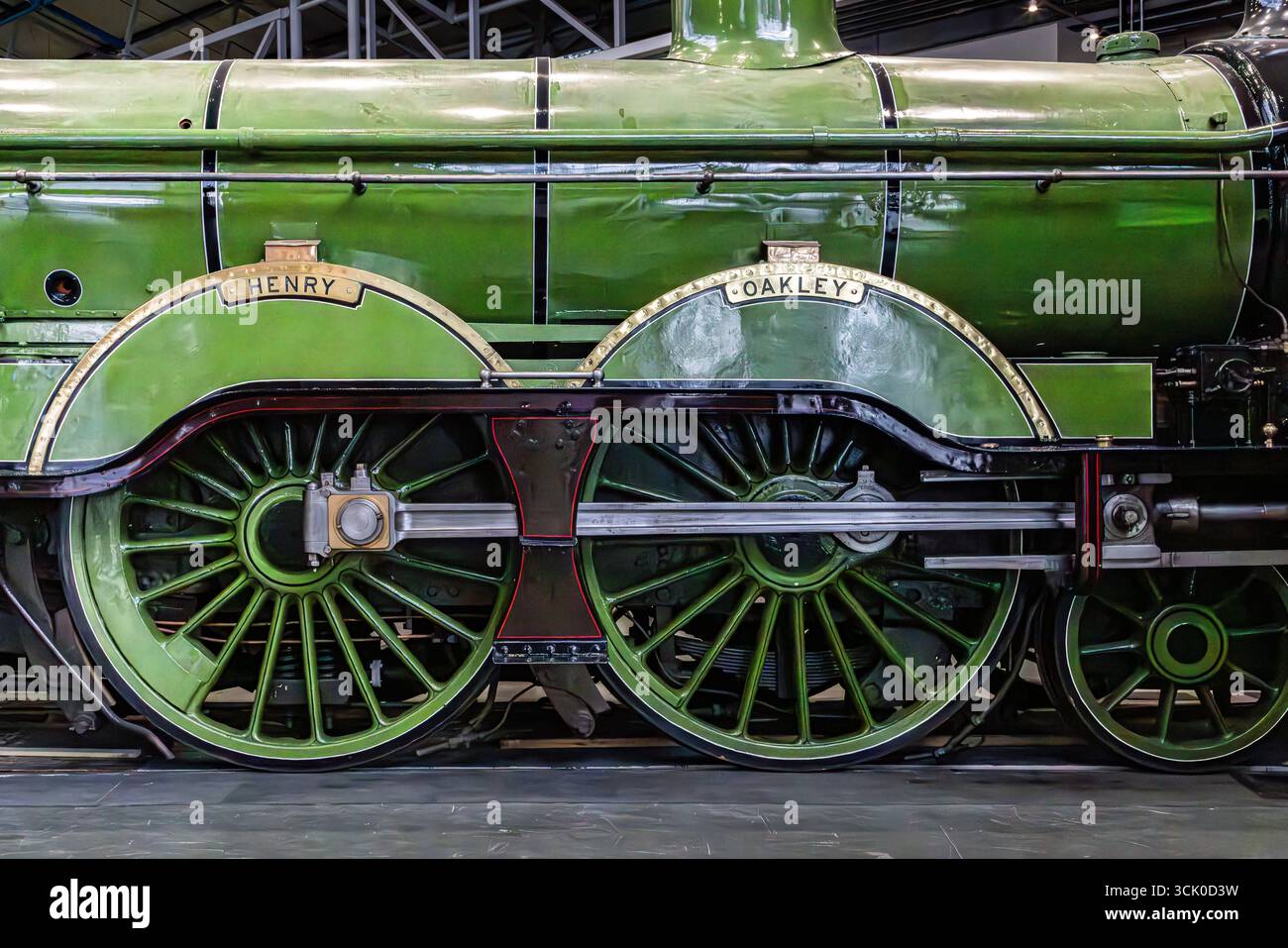 Primo piano della locomotiva a vapore verde "Henry Oakley" al National Railway Museum di York, che mostra ruote a raggi e dettagli meccanici. Foto Stock