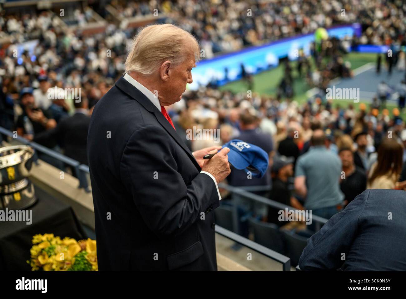 Il presidente Donald J. Trump firma un berretto per un tifoso mentre partecipa allo U.S. Open Men's Championship alla finale maschile degli U.S. Open all'Arthur Ashe Stadium di Queens, New York. USTA Billie Jean King National Tennis Center il 7 settembre 2025. Foto Stock