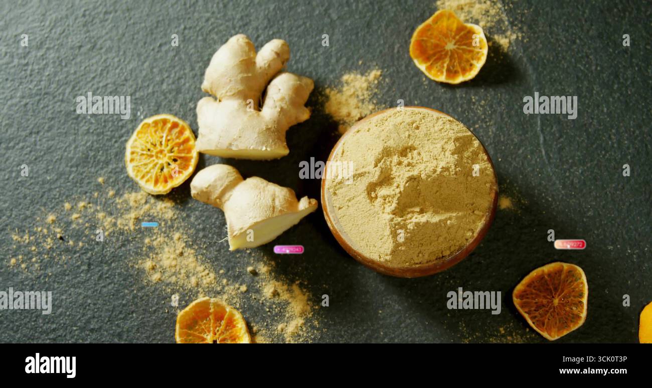 Mostra una ciotola di legno di zenzero in polvere con radice di zenzero affettata, fette di agrumi secche sulla superficie di pietra Foto Stock