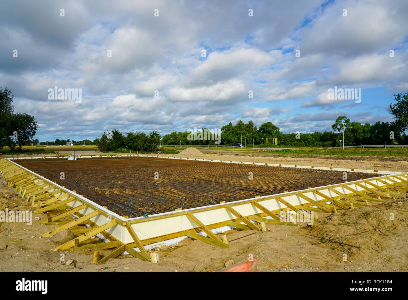 Fondazioni con isolamento termico, armature in acciaio e casseforme in legno preparate per versare solette in calcestruzzo nei cantieri edili Foto Stock