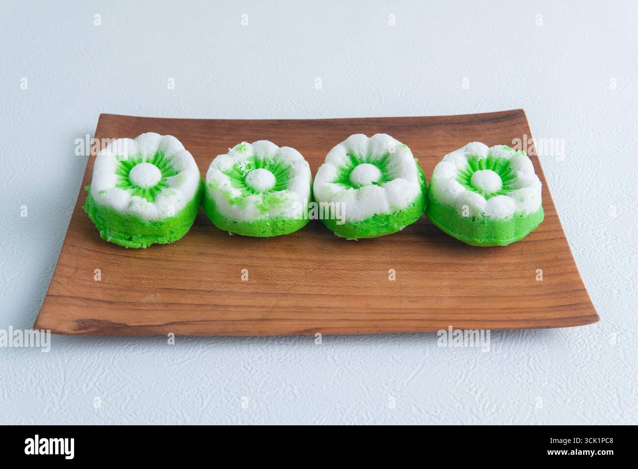 Putu ayu con torte al vapore indonesiane preparate al momento e ricoperte di cocco su un tavolo di legno, tradizionale spuntino fatto in casa. Foto Stock