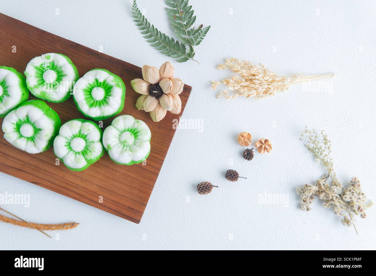 Putu ayu con torte al vapore indonesiane preparate al momento e ricoperte di cocco su un tavolo di legno, tradizionale spuntino fatto in casa. Foto Stock