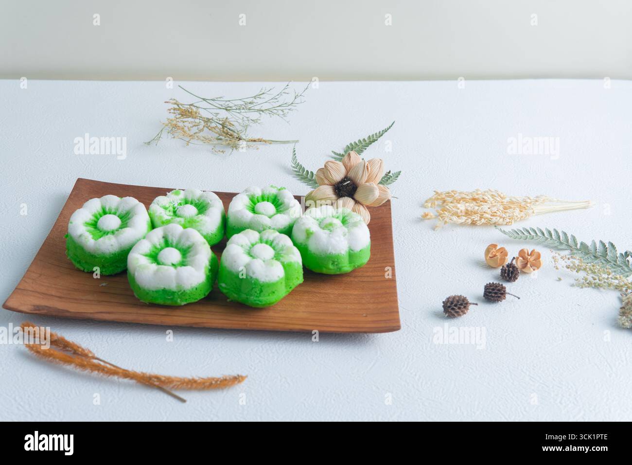 Putu ayu con torte al vapore indonesiane preparate al momento e ricoperte di cocco su un tavolo di legno, tradizionale spuntino fatto in casa. Foto Stock