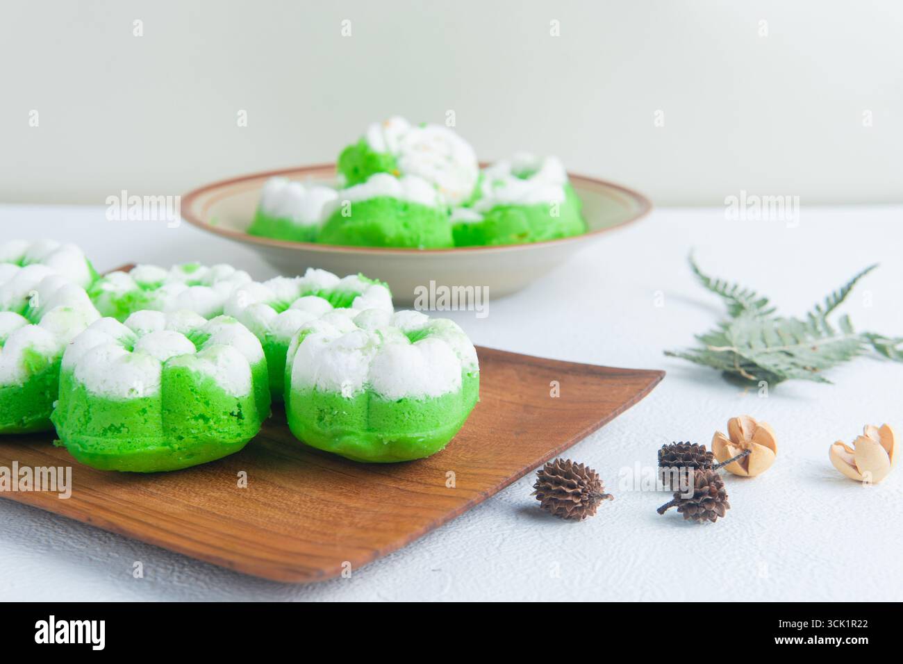 Putu ayu con torte al vapore indonesiane preparate al momento e ricoperte di cocco su un tavolo di legno, tradizionale spuntino fatto in casa. Foto Stock
