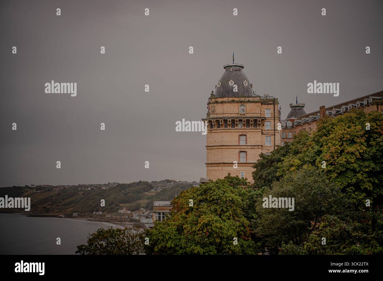 Storico edificio a torre a cupola con vista laterale e alberi Foto Stock