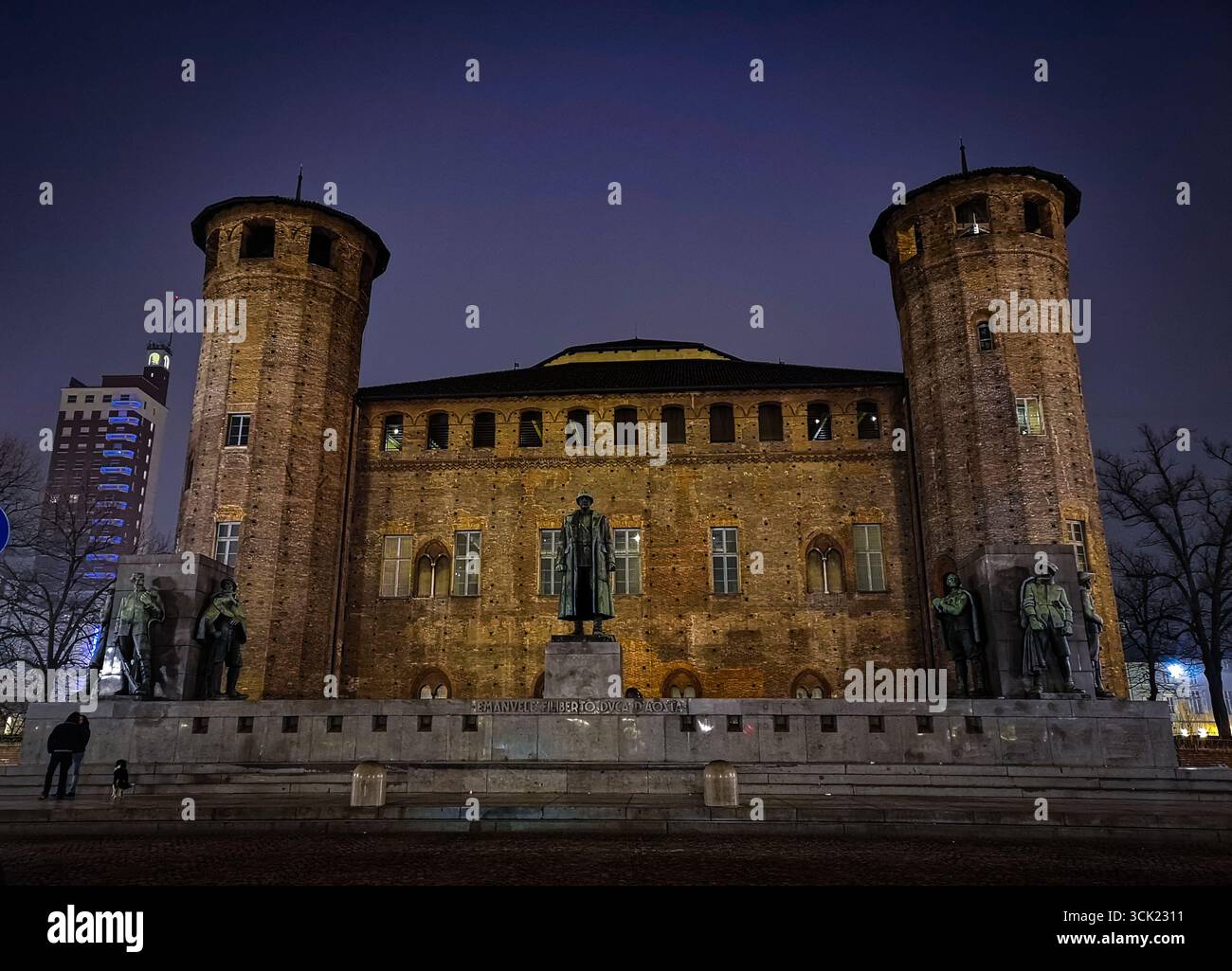 Una vista notturna dello storico Palazzo Madama di Torino. La grande facciata, con le sue due torri medievali, è splendidamente illuminata contro il da - Immagine stock catturata con smartphone