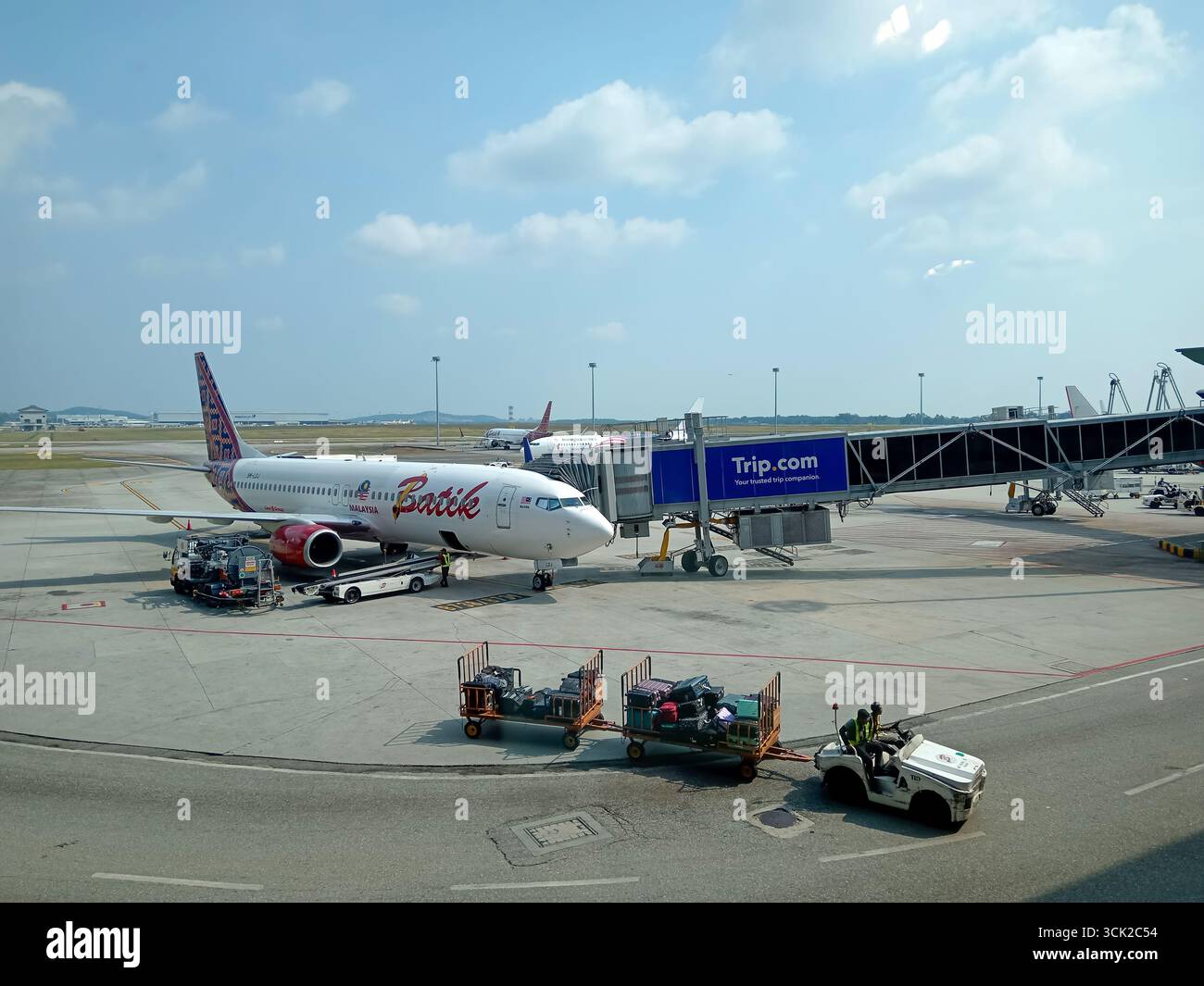 Kuala Lumpur, Malesia - 3 marzo 2025: Un aereo sta caricando i bagagli sull'asfalto all'aeroporto internazionale di Kuala Lumpur. La connessione Skybridge Foto Stock