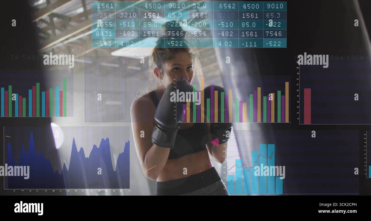 Pugile donna in piedi con guanti, reggiseno sportivo in palestra, con borsa pesante, analisi galleggianti Foto Stock